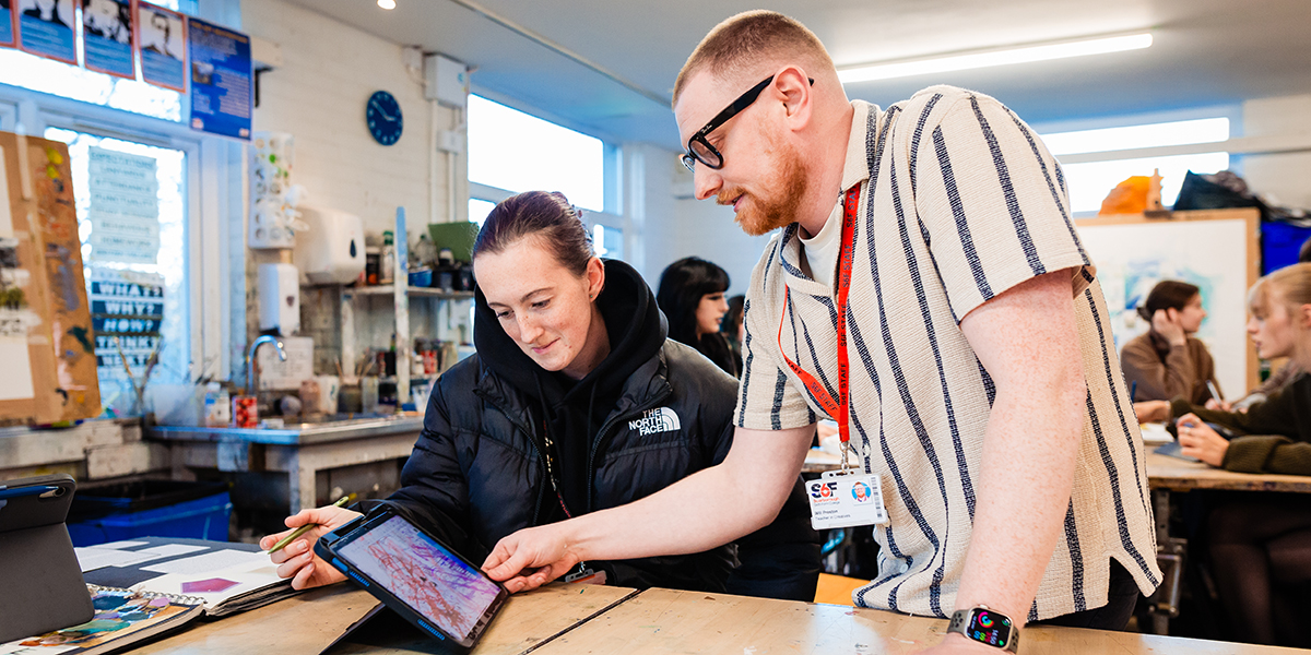 A teacher supporting a student working on an iPad